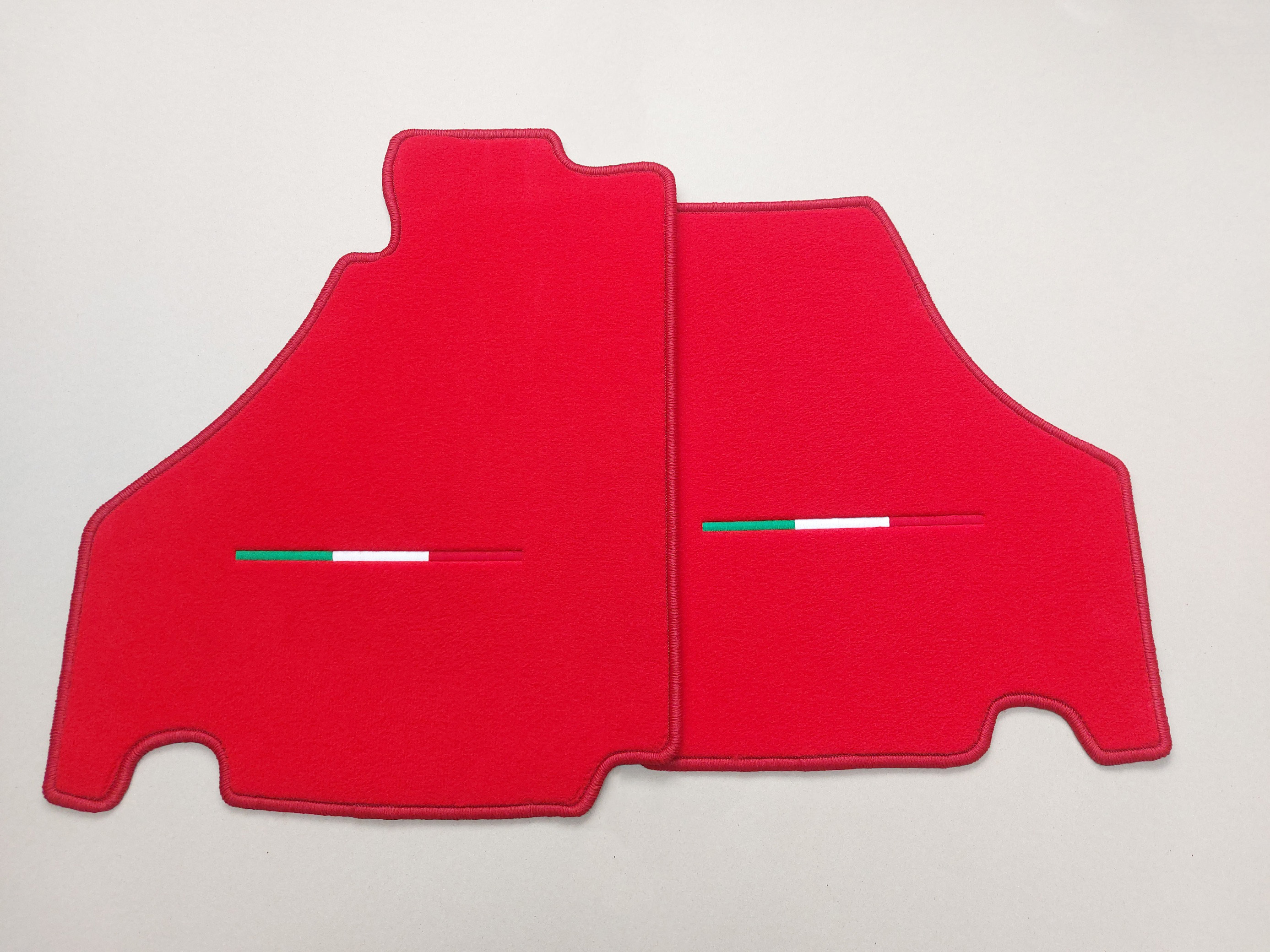 Zwei Fussmatten fuer einen Ferrari in rot mit Tricolore Stick.